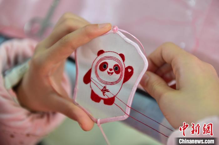圖為一名小學(xué)生正在繡制2022年北京冬奧會吉祥物“冰墩墩”形象。　喻云亮 攝
