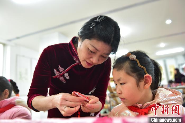 江西省級非遺豫章繡傳承人手把手指導(dǎo)小學(xué)生繡制2022年北京冬奧會吉祥物“冰墩墩”形象?！∮髟屏?攝