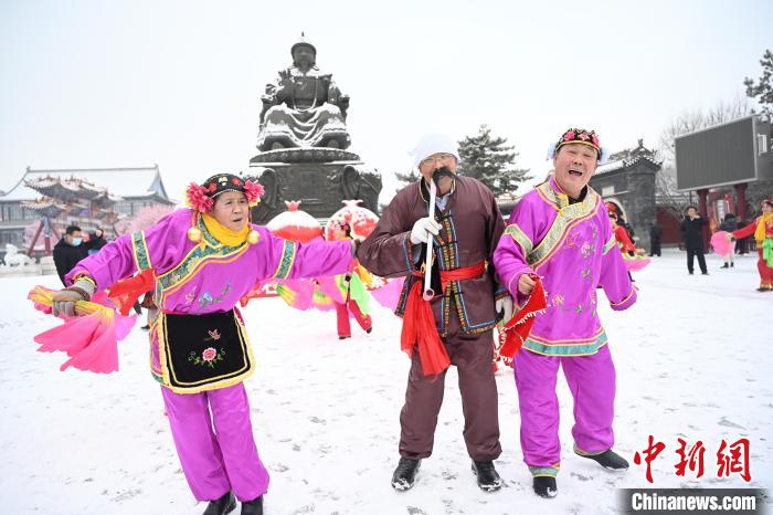 2月13日，秧歌隊在呼和浩特市大召廣場雪中起舞?！⑽娜A 攝