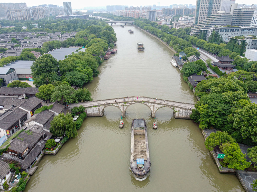 5月27日，一艘貨船駛過京杭大運(yùn)河南端標(biāo)志建筑杭州拱宸橋。(無人機(jī)照片)新華社記者江漢 攝