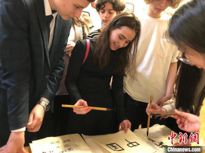 4月21日，莫斯科國立語言大學(xué)孔子學(xué)院附屬中學(xué)舉辦“國際中文日”活動，學(xué)生們學(xué)寫漢字?！∧箍茋⒄Z言大學(xué)孔子學(xué)院 供圖
