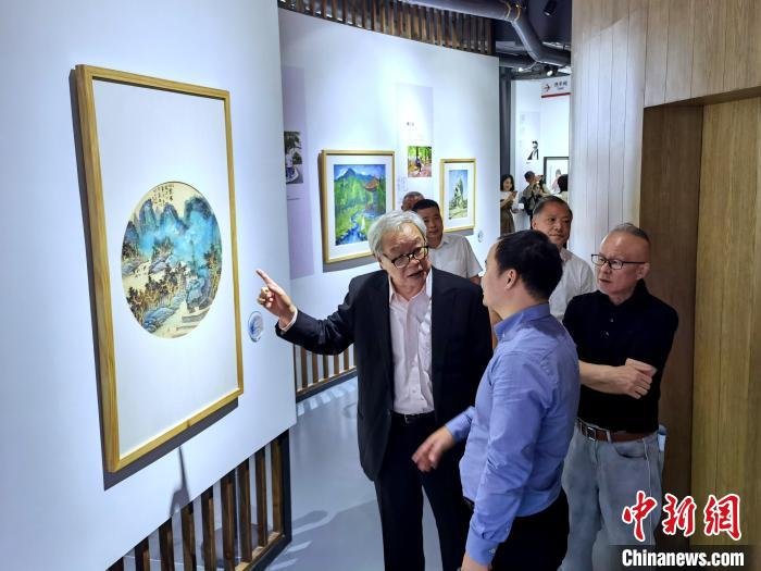 海峽兩岸藝術(shù)家畫展上，藝術(shù)家進(jìn)行藝術(shù)交流?！「毒窜?攝