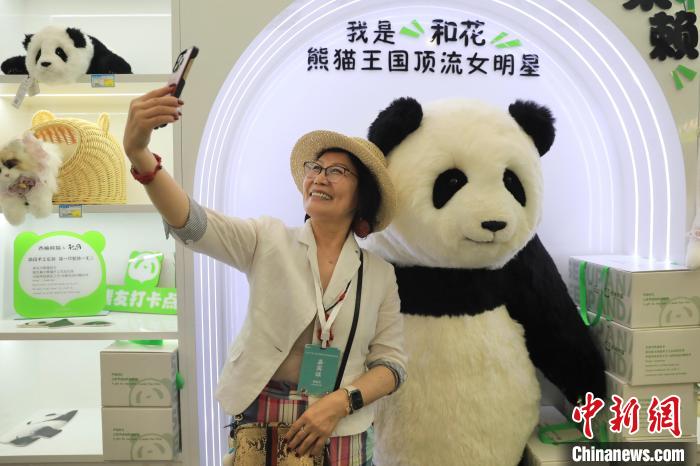 美國華視總裁楊蓮花與大熊貓文創(chuàng)產(chǎn)品合影?！⊥趵?攝