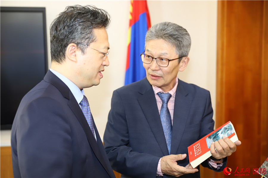 其米德策耶（右一）向李峙介紹翻譯成果。人民網(wǎng)記者 霍文攝