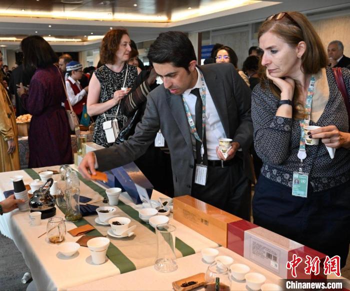 現(xiàn)場觀眾觀看中國展臺茶藝表演、了解茶文化。　靖樹 攝