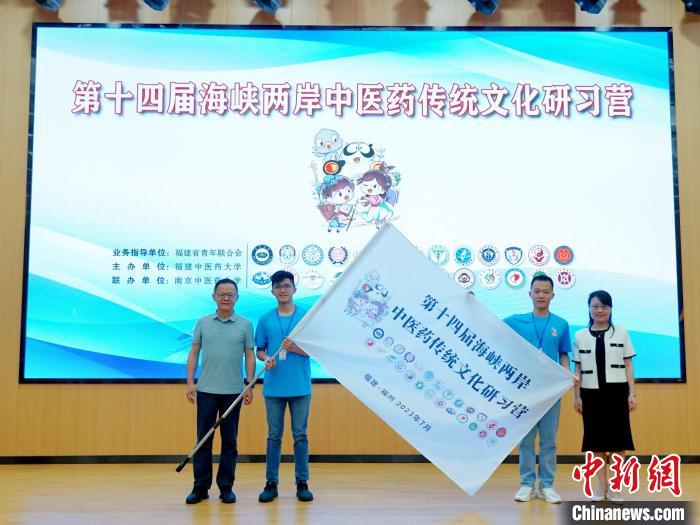 共青團(tuán)福建省委副書記吳雪(右一)、福建中醫(yī)藥大學(xué)黨委副書記林羽(左一)為兩岸學(xué)生代表頒授營(yíng)旗?！≡S燁婷 攝