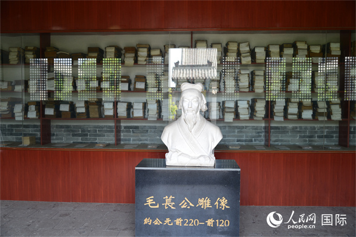 河間詩(shī)經(jīng)齋毛萇雕像。雕像后書(shū)櫥中陳列的是歷代各版本《詩(shī)經(jīng)》及譯本。 人民網(wǎng) 趙昭攝