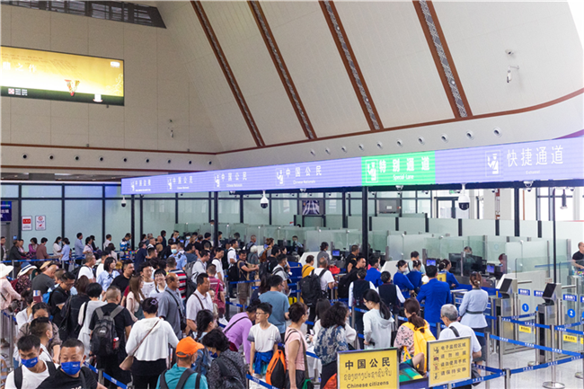 7月22日，乘坐中老鐵路國際旅客列車的旅客在磨憨邊檢大廳排隊候檢。衛(wèi)海林 攝