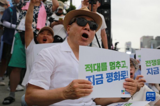 7月22日，在韓國首爾，人們手舉標語參與反戰(zhàn)游行。新華社發(fā)（楊暢 攝）