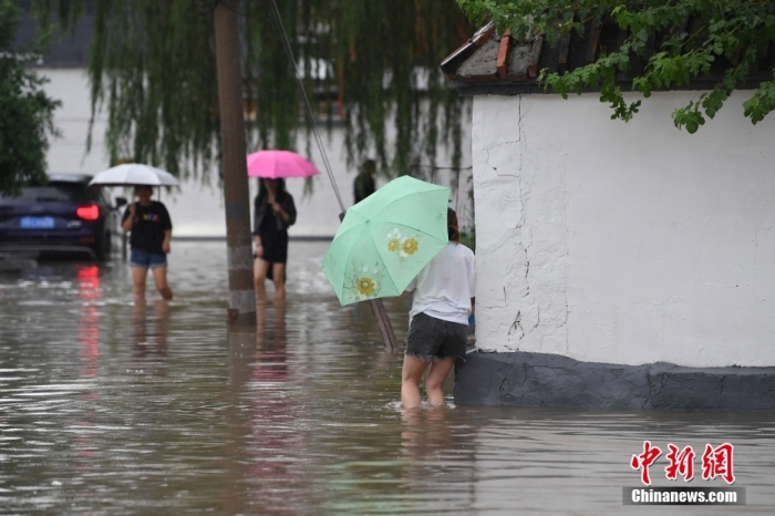 7月31日，市民行走在雨中的北京房山區(qū)瓦窯頭村。北京市氣象臺當日10時發(fā)布分區(qū)域暴雨紅色預警信號。北京市水文總站發(fā)布洪水紅色預警，預計當日12時至14時，房山區(qū)大石河流域將出現(xiàn)紅色預警標準洪水。<a target='_blank' href='/'><p  align=