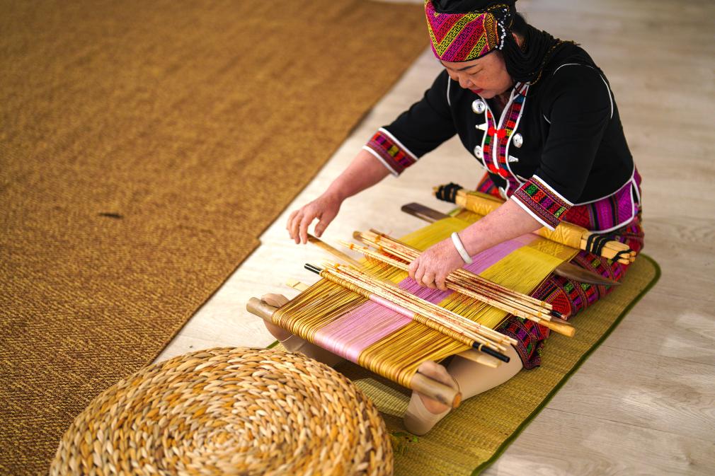 4月17日，黎族傳統(tǒng)紡染織繡技藝國(guó)家級(jí)代表性傳承人劉香蘭在2023年意大利米蘭設(shè)計(jì)周上展示黎錦織造技藝。新華社發(fā)