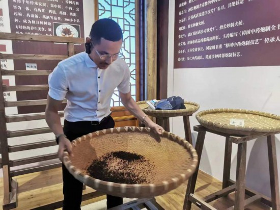 2023“一帶一路”媒體合作論壇聯(lián)合采訪團團員在非遺文化展示館體驗中藥炮制技藝。（本報記者 黃超攝）