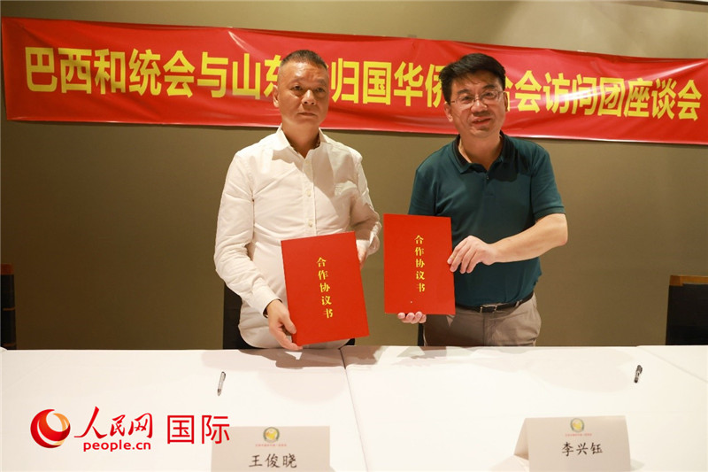 中國僑聯(lián)副主席、山東省僑聯(lián)主席李興鈺（右）與巴西和統(tǒng)會會長王俊曉簽署合作協(xié)議書。人民網(wǎng)記者 陳海琪攝