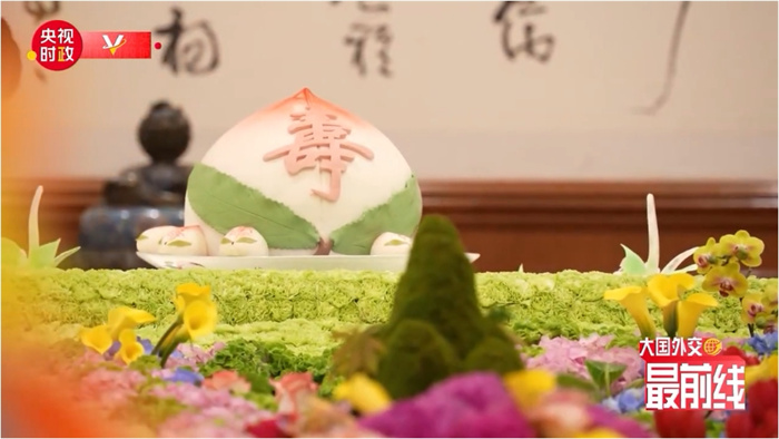 圖為今年7月基辛格訪華時(shí)午宴上的壽桃。來(lái)源：央視新聞截圖