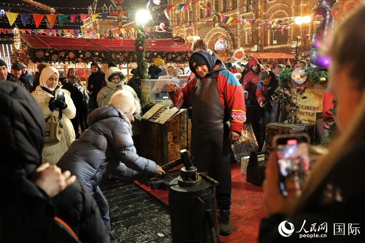 游客在新年集市上體驗(yàn)制作紀(jì)念幣。人民網(wǎng)記者 隋鑫攝