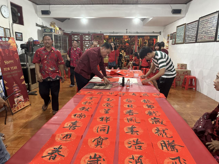 茍皓東為華人朋友現(xiàn)場寫春聯(lián)送福字。巴陵康孔子學(xué)院供圖
