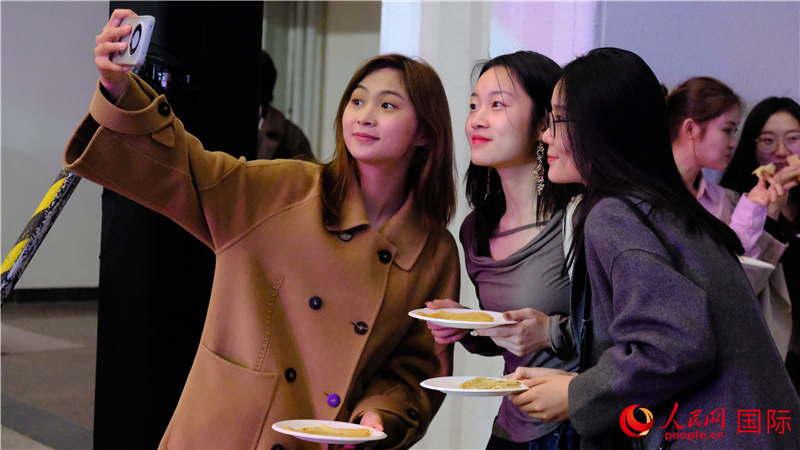 中國觀眾在現(xiàn)場品嘗“謝肉節(jié)”節(jié)日美食——煎薄餅。人民網(wǎng) 褚夢琦攝
