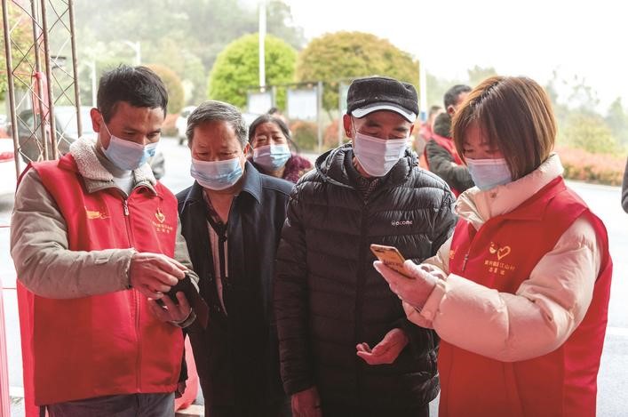長沙縣黨員志愿者正在幫助參與核酸檢測的群眾掃描“場所碼”。劉思源 攝