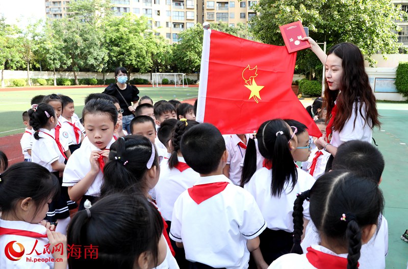 老師向少先隊(duì)員展示隊(duì)旗。人民網(wǎng) 符武平攝
