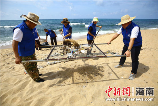 環(huán)保志愿者用篩網(wǎng)“淘”出海灘上的垃圾。