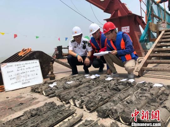 圖為勘察設計人員與海事局工作人員查看巖芯情況?！∥赫?攝