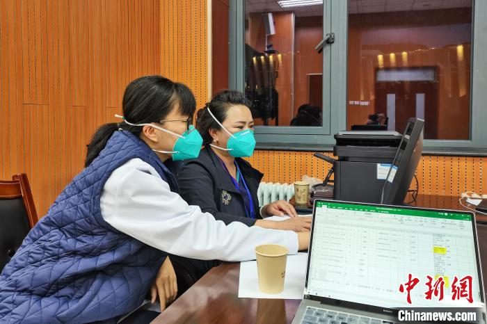 8月9日，楊蘇喬(左)在拉薩方艙醫(yī)院指揮部讀取艙內(nèi)患者胸部CT。　受訪者供圖