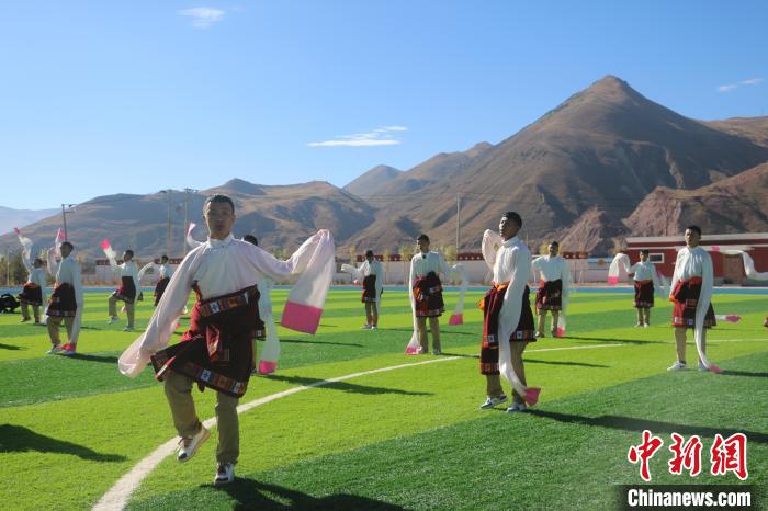 圖為青海師范大學(xué)附屬玉樹實(shí)驗(yàn)學(xué)校學(xué)生在綠茵場跳起囊謙古舞—卓根瑪?！〕逃?攝