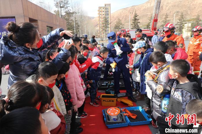 圖為小朋友們聽消防員講解消防器材。　楊龍建 攝