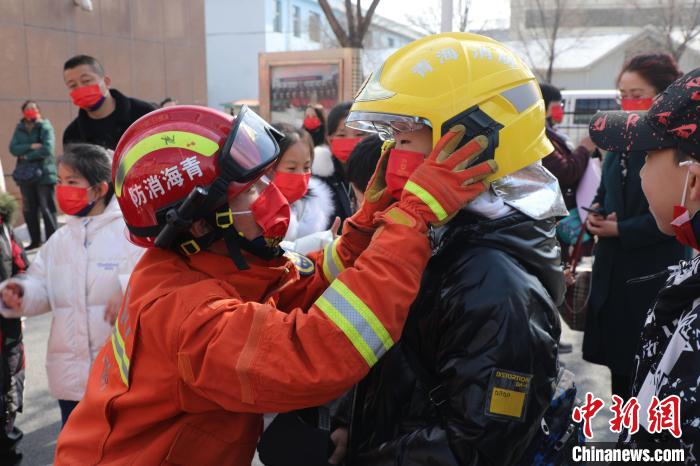 圖為小朋友體驗(yàn)試穿消防滅火防護(hù)服。　楊龍建 攝