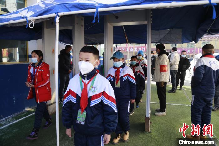 圖為學生測量體溫后進入校園?！●R銘言 攝