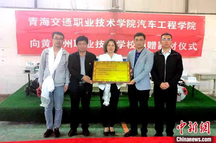 圖為李富香(中)代表學(xué)校為州縣技校捐贈器材。(資料圖) 青海省教育廳供圖