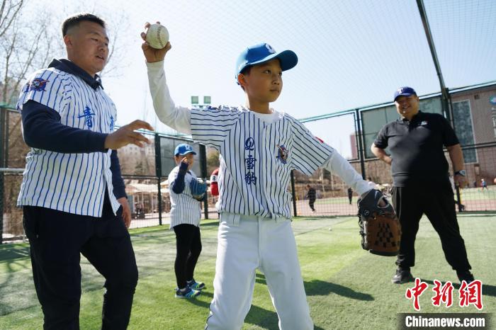 圖為教練指導(dǎo)小棒球手?jǐn)S球技術(shù)?！●R銘言 攝