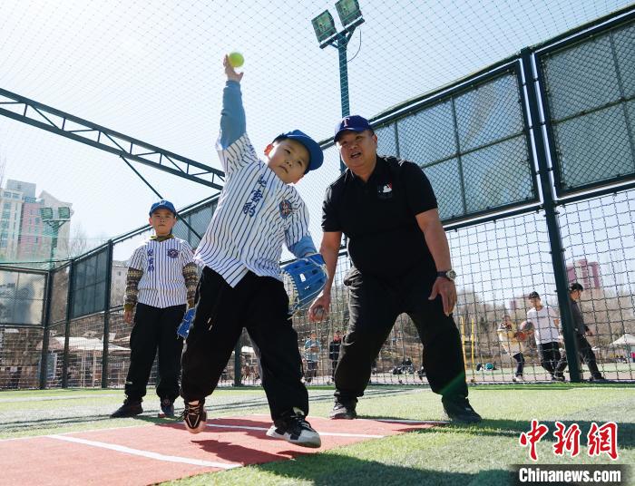 圖為來自臺(tái)灣的棒球教練劉興鴻(右)指導(dǎo)小棒球手?jǐn)S球技術(shù)。　馬銘言 攝