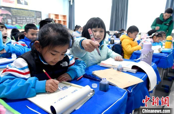 3月14日，西藏拉薩市第一小學(xué)一年級(jí)六班學(xué)生白瑪朗珍(圖左)在藏語(yǔ)文課上書(shū)寫(xiě)藏文?！±盍?攝