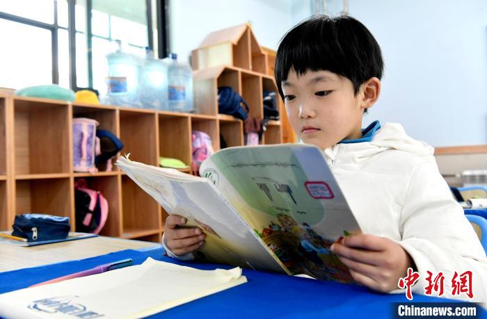 3月14日，西藏拉薩市第一小學(xué)一年級(jí)六班學(xué)生丁增樂(lè)吉在閱讀藏語(yǔ)課本。　李林 攝