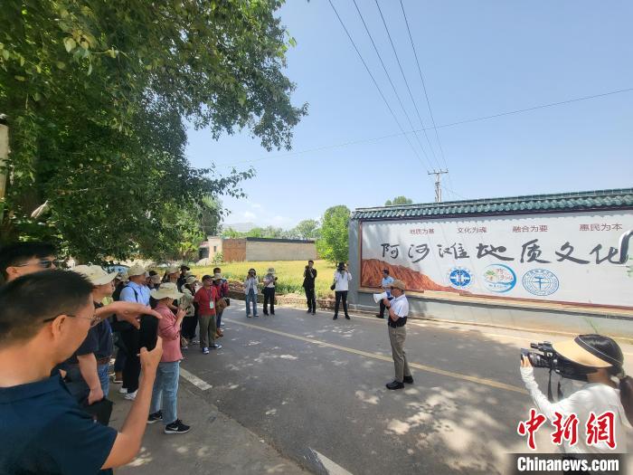 圖為中國地質(zhì)大學(xué)(北京)教授張緒教介紹村落情況?！『衍?攝