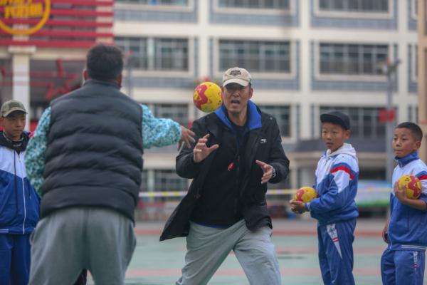在高原上教孩子們打手球，“慢慢兒來，甭著急！”