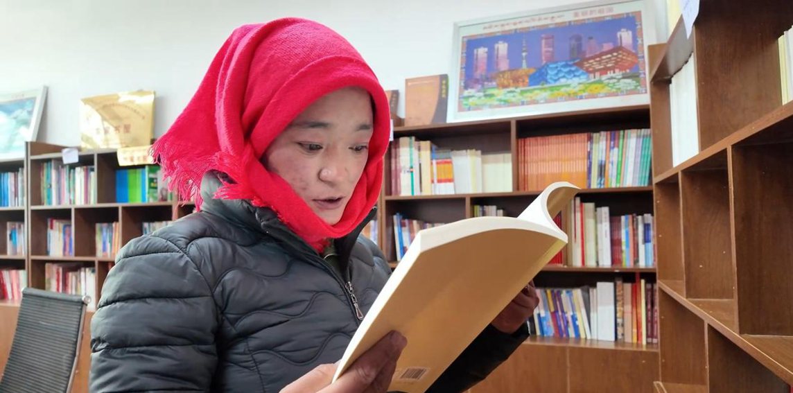 一名婦女正在認(rèn)真閱讀書(shū)籍。申扎縣融媒體中心供圖