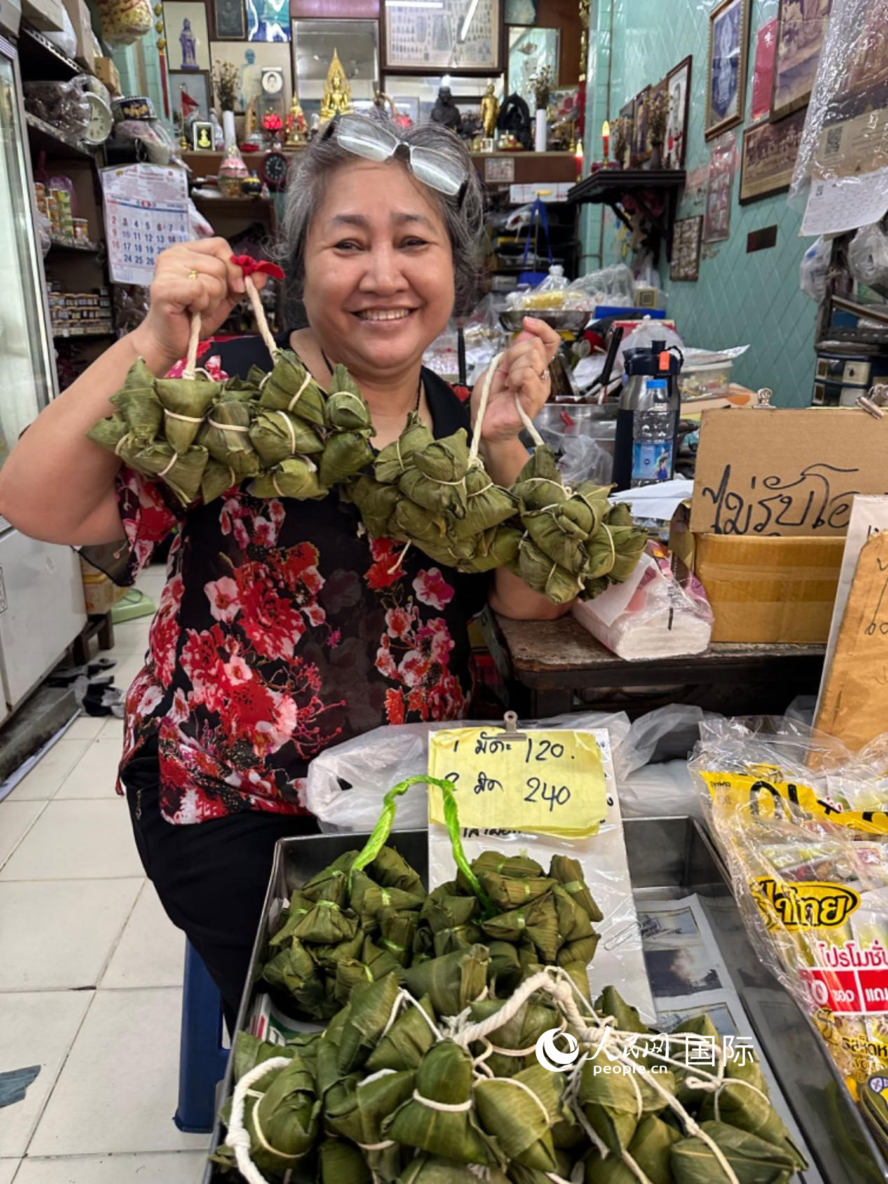 商家向顧客介紹“吉掌”（粽子的一種，一串一串，個(gè)頭較?。Ｈ嗣窬W(wǎng)記者 簡(jiǎn)承淵攝