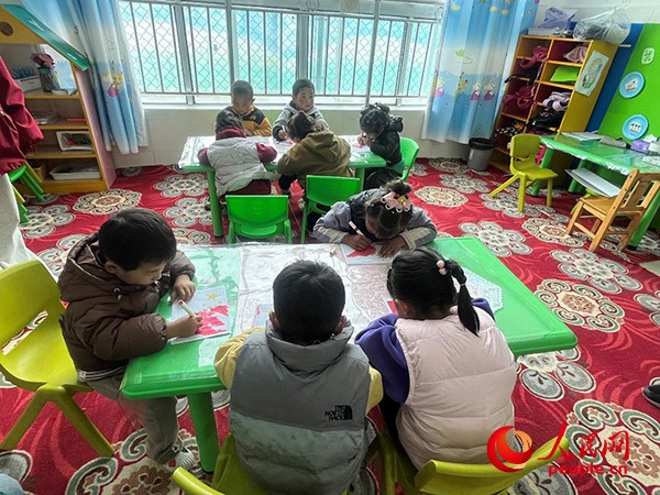 拉多村一所現(xiàn)代化幼兒園小班孩子們正在繪畫。張敏穎 攝
