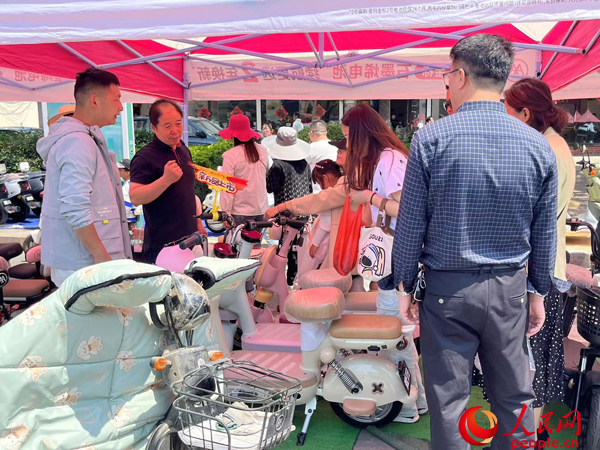 某電動自行車品牌工作人員向消費者介紹以舊換新相關(guān)情況。人民網(wǎng)記者 杜燕飛攝