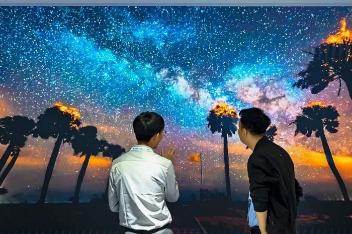 長春光博會希達電子展區(qū)，一位工作人員正在給一位觀眾講解。（長春新區(qū)供圖）