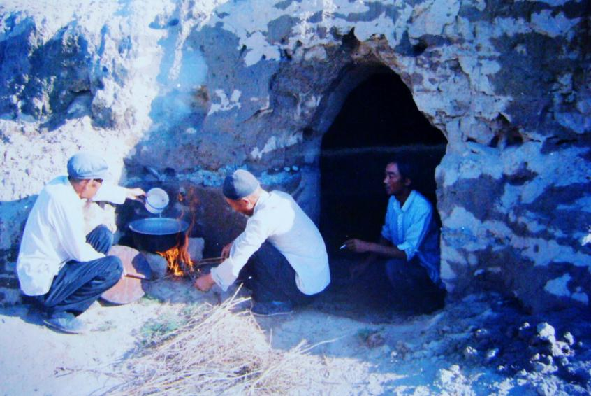 1983年，“六老漢”一代治沙人在“地窩子”生活做飯。新華社發(fā)（八步沙林場供圖）