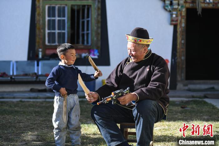 圖為米林縣扎西繞登鄉(xiāng)彩門村64歲的洛桑帶著孫子巴桑在院子的草地上玩耍?！『闻罾?攝