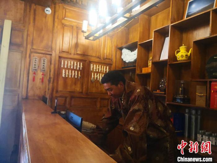 圖為桑杰才讓用電腦處理財務(wù)?！∈缝o靜 攝