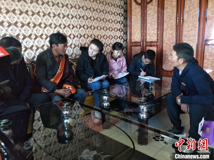 圖為調(diào)查組工作人員正在入戶調(diào)查?！∑钤鲚?攝
