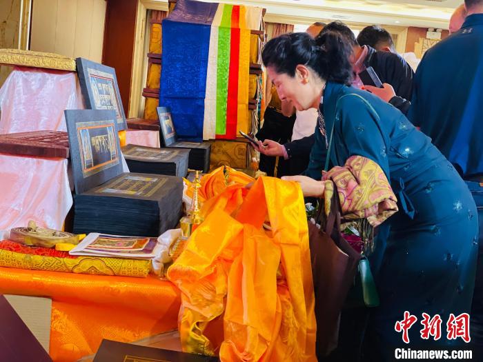 圖為現(xiàn)場藏族民眾向黃金書寫的大藏經(jīng)《甘珠爾》敬獻(xiàn)哈達(dá)。　孫睿 攝
