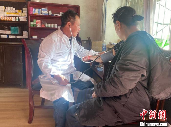 索木滾(左)為村民看病?！∪捞量h委宣傳部供圖