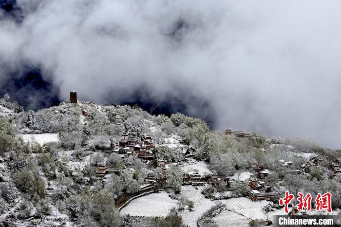 雪后的藏寨和碉樓構(gòu)成美麗的雪景?！〗党鯘衫?攝