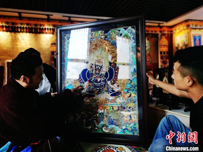 圖為久美尖措(左)與徒弟們展示唐卡作品?！?zhí)砀?攝